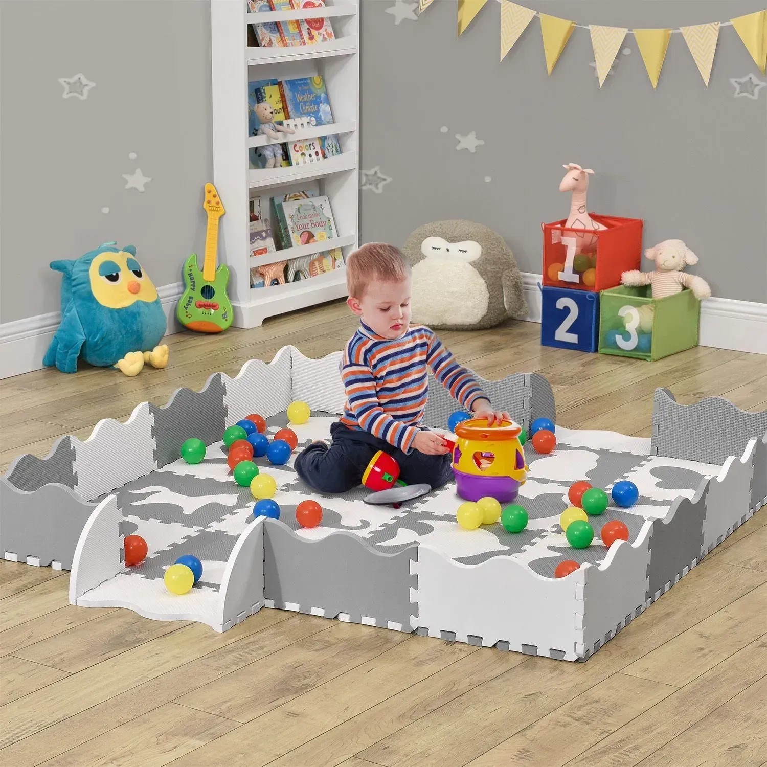 Juskys Kinder Puzzlematte Timon, 36-teilig, mit Tiermotiven in Grau/Weiß, Kind spielt darauf.