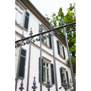 Eleo Zaun Lucca, unbeschichtet, 192,5 cm, Schmiedeeisen, mit Zierspitzen vor einem Haus.