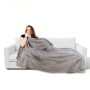 Frau kuschelt in hellgrauer Bestgoodies Mikrofaser Decke (220x240 cm) auf Sofa. Weiche Wohndecke.