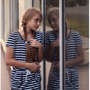 Mädchen vor Fenster mit Venilia Spiegelfolie: Sichtschutz und Spiegeleffekt.