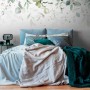 Fototapete Floral in Grün, Blau und Weiß von PROFHOME im Schlafzimmer.