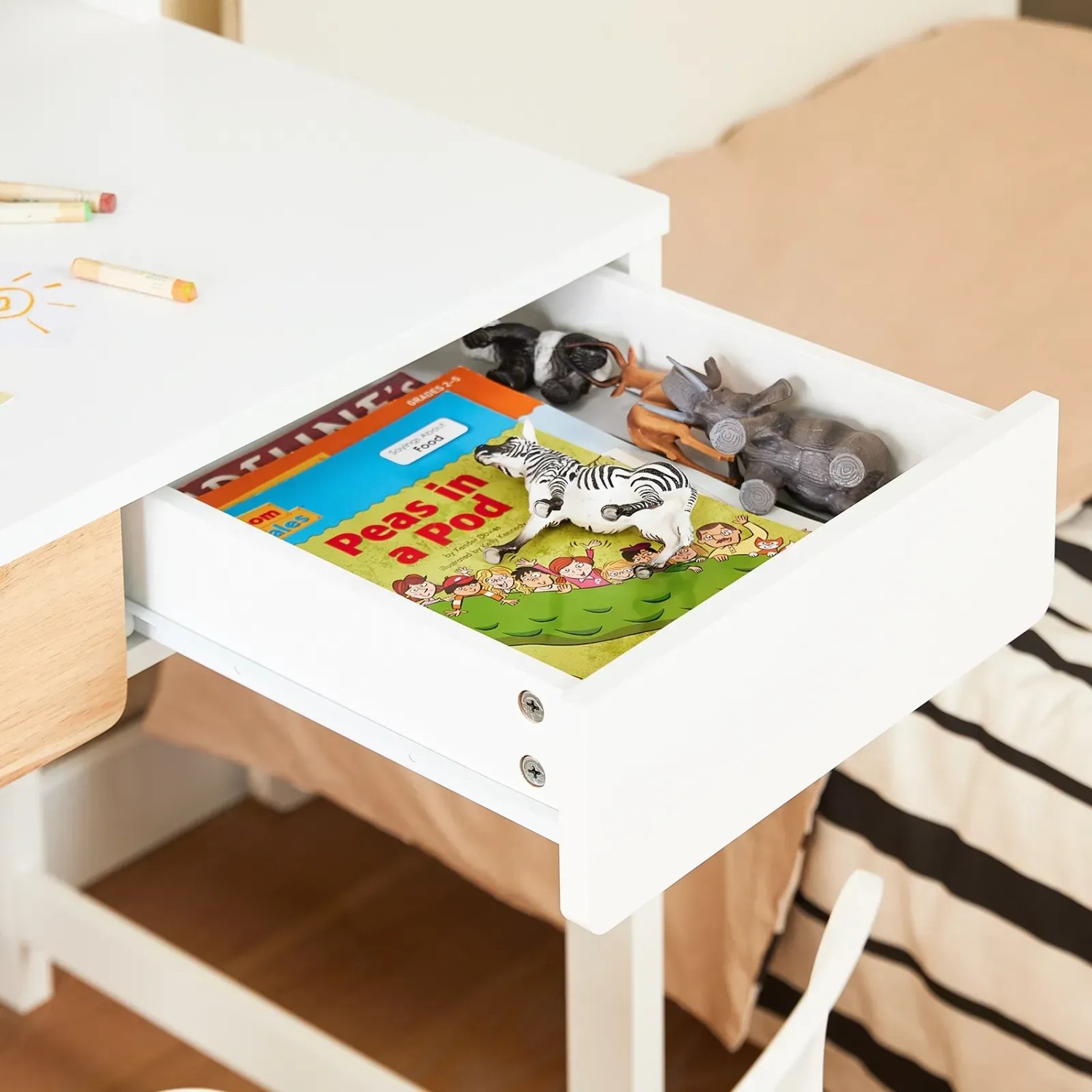 Weißer SoBuy Schreibtisch FWT106-W mit Schublade, gefüllt mit Spielzeug und Buch.