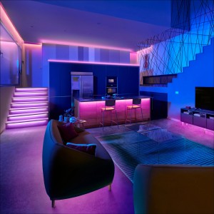 Wohnraum mit WiZ Smart LED Streifen in RGB Farben an Treppe, Decke und Kücheninsel.