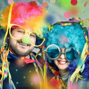 Lachende Partygäste mit bunten Perücken und Brillen, umgeben von fallendem Konfetti. Perfekt für Konfettikanone & Party Popper.