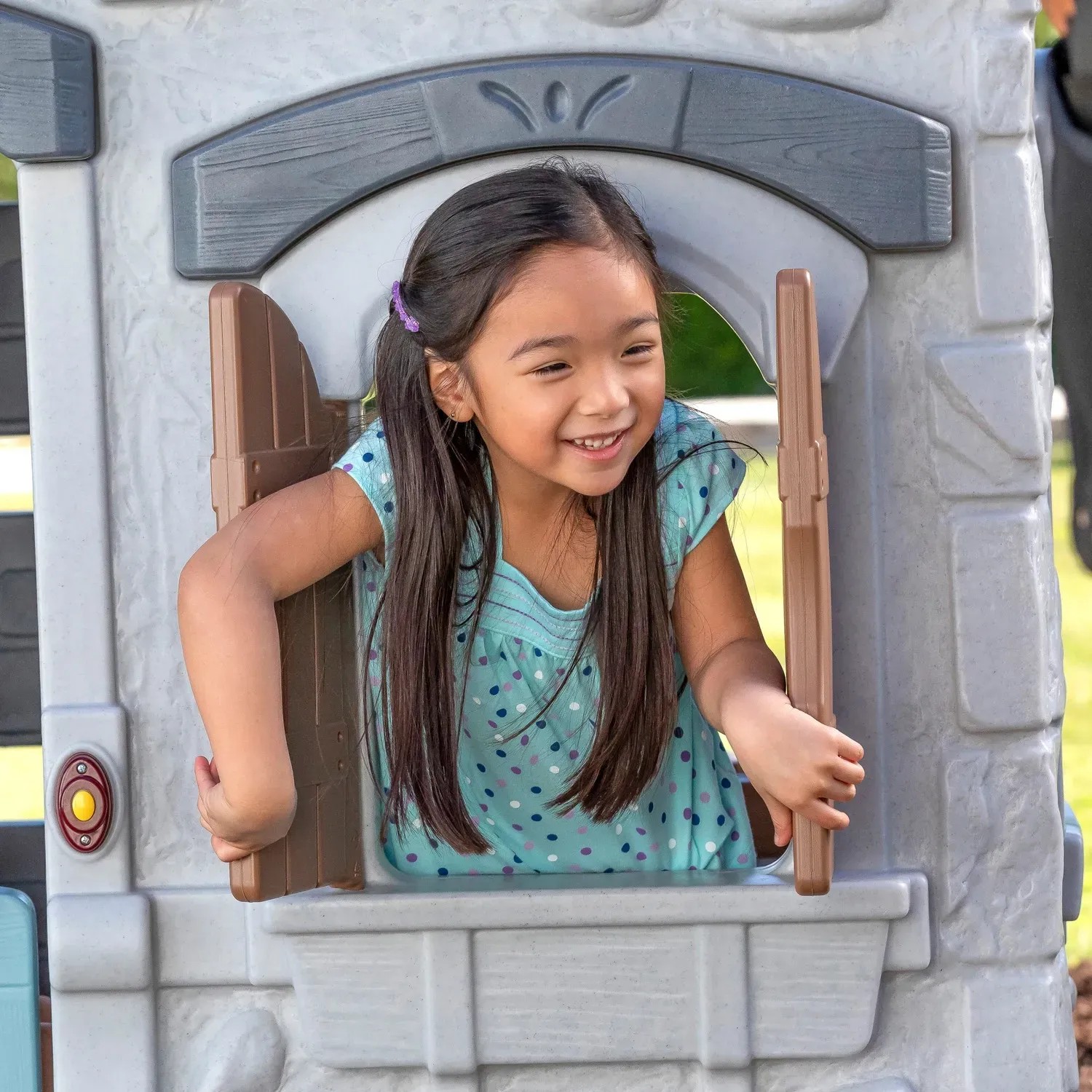 Kind spielt im Step2 Spielhaus Adventures mit Fenster und Rutsche.