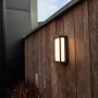 Moderne Lutec LED-Außenwandleuchte Qubo an Holzwand, warmweißes Licht.