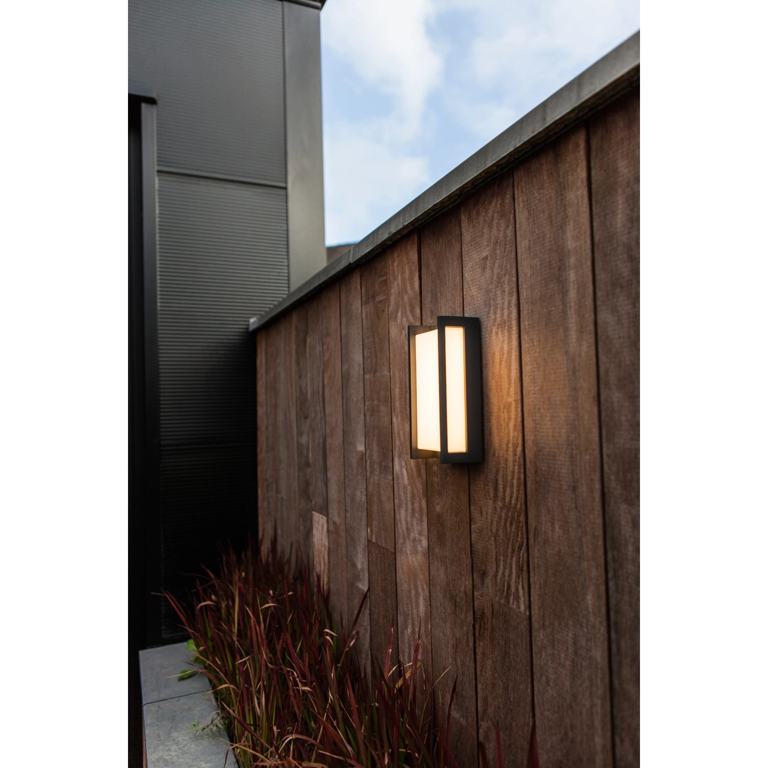 Moderne Lutec LED-Außenwandleuchte Qubo an Holzwand, warmweißes Licht.