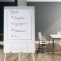 Weißes Relaxdays Flipchart Whiteboard (90x60 cm) auf silbernem Aluminium-Dreibein im Büro. Mit Agenda-Papier & Stifteablage.