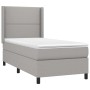 Helles Boxspringbett 100x200 cm mit Matratze und Kopfteil, grauer Stoff Bezug.