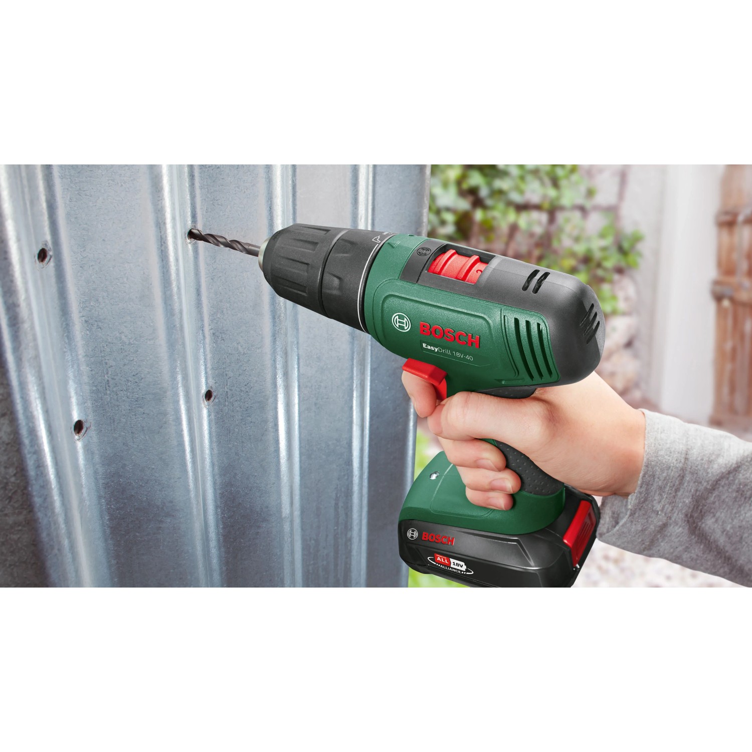 Bosch Akkubohrschrauber EasyDrill 18V-40 in Grün bohrt präzise in eine silberne Metallplatte. Vielseitiger Akkuschrauber.