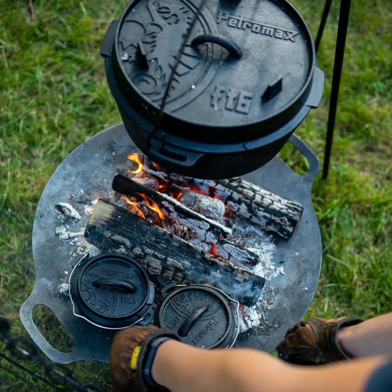 Petromax Dutch Oven FT6 auf Feuerstelle mit Holz und Glut. Gusseisen Topf zum Kochen im Freien.