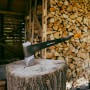Fiskars X-series Spalt-Axt X36 (91,5 cm) auf Holzscheit vor Holzstapel.