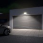 Schwarzer LED Außenstrahler mit Bewegungsmelder beleuchtet Garage und Auto neutralweiß.