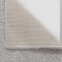 Grauer Flair Rugs Hochflorteppich Feather Soft mit zotteligem Flor. Eine Ecke zeigt die Jute-Unterlage auf hellem Holzboden.