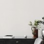 Helle Vliestapete Uni Weiß Metallic FSC® an Wand über Kommode im Wohnraum.