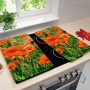 Wenko Herdabdeckplatten Mohnfeld 2er-Set auf einem Herd, mit Mohnblumen-Motiv.