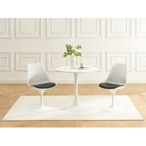 Zwei weiße Design Esszimmerstühle Xafy mit schwarzen Sitzen und Tulpenfuß an einem runden Tisch.