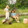Grauer Home Deluxe Hängesessel Cielo Polyrattan mit Personen im Garten.
