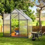 Graues Palram Canopia Gewächshaus (3,4 m²) mit geöffneter Tür und Fundamentrahmen im Garten.
