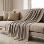 The White Stone Sofadecke Taupe, Baumwoll-Mix, mit Fransen auf Sofa. Leichte Wohndecke.