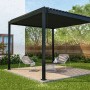 Anthrazitfarbene Mirador Basic Pergola 3x3 m im Garten mit Sitzbereich.