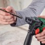 Bosch Akku-Bohrhammer UniversalHammer 18V mit Bohrer in der Hand, SDS-Plus Aufnahme.