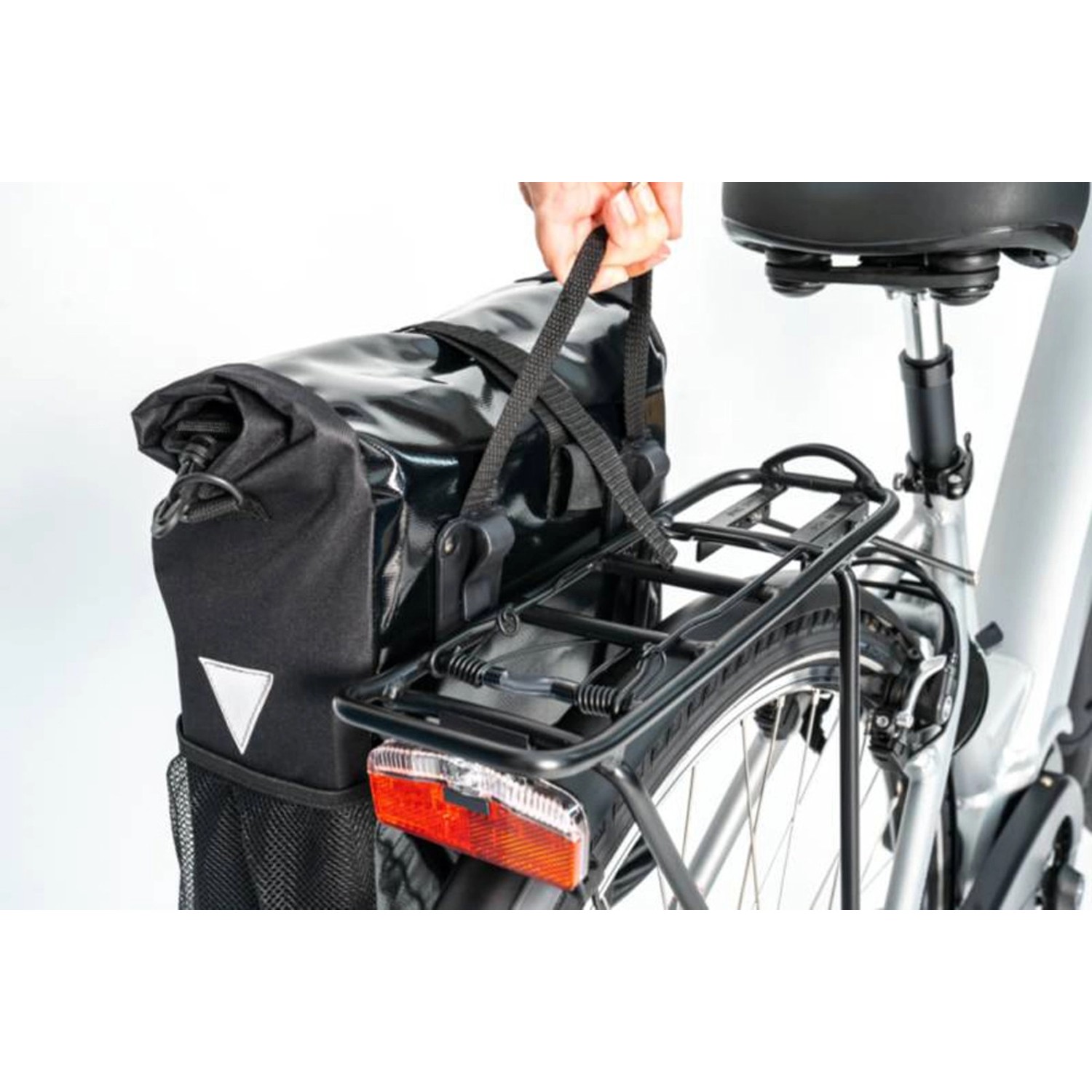 Schwarze Fischer Kurier Fahrrad-Gepäckträgertasche mit Reflektor am Fahrrad befestigt.