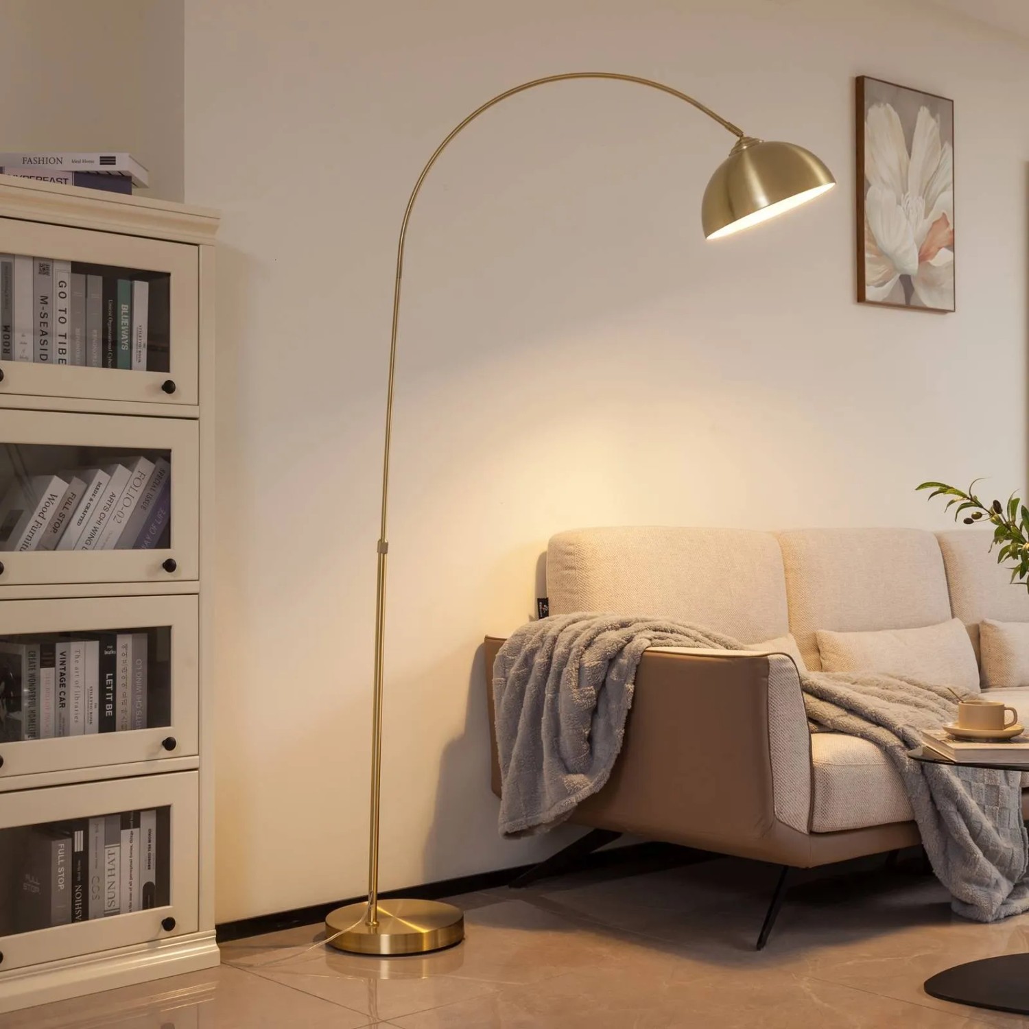 Goldene Bogenleuchte Lennart aus Metall im modernen Design, leuchtet ein Wohnzimmer mit warmem Licht.