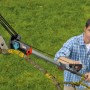 Mann schneidet Ast mit Gardena Amboss-Baumschere. Gartenschere mit Rollenübersetzung für trockene Äste.