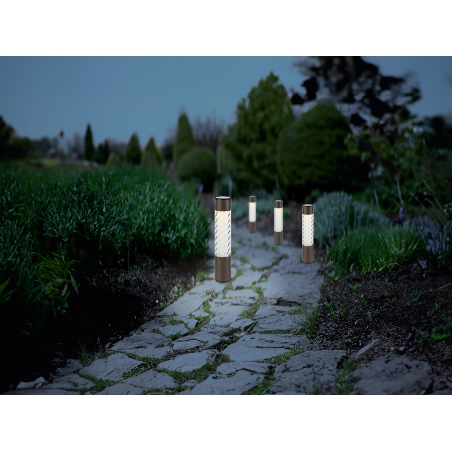 Solar-LED-Dekoleuchten Isili 4er-Set entlang eines Gartenwegs. Außenleuchten für stimmungsvolle Beleuchtung.