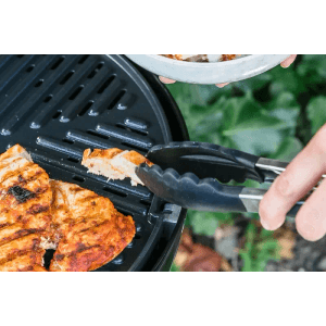 CADAC Grillzange (28cm) im Einsatz: Grillgut wird gewendet.