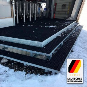 Schwarze KARAT Ringgummimatte Octo Door als rutschfester Belag auf Treppe im Schnee.