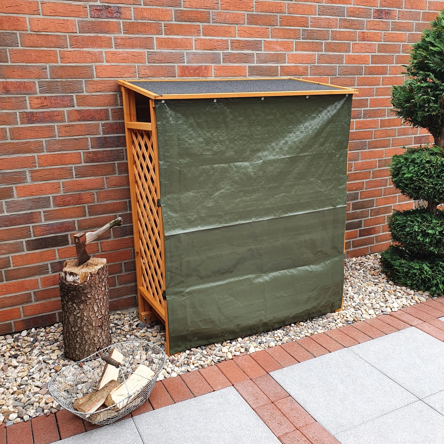 Honigbraunes Kaminholzregal Speyer mit Wetterschutzplane vor einer Ziegelwand.