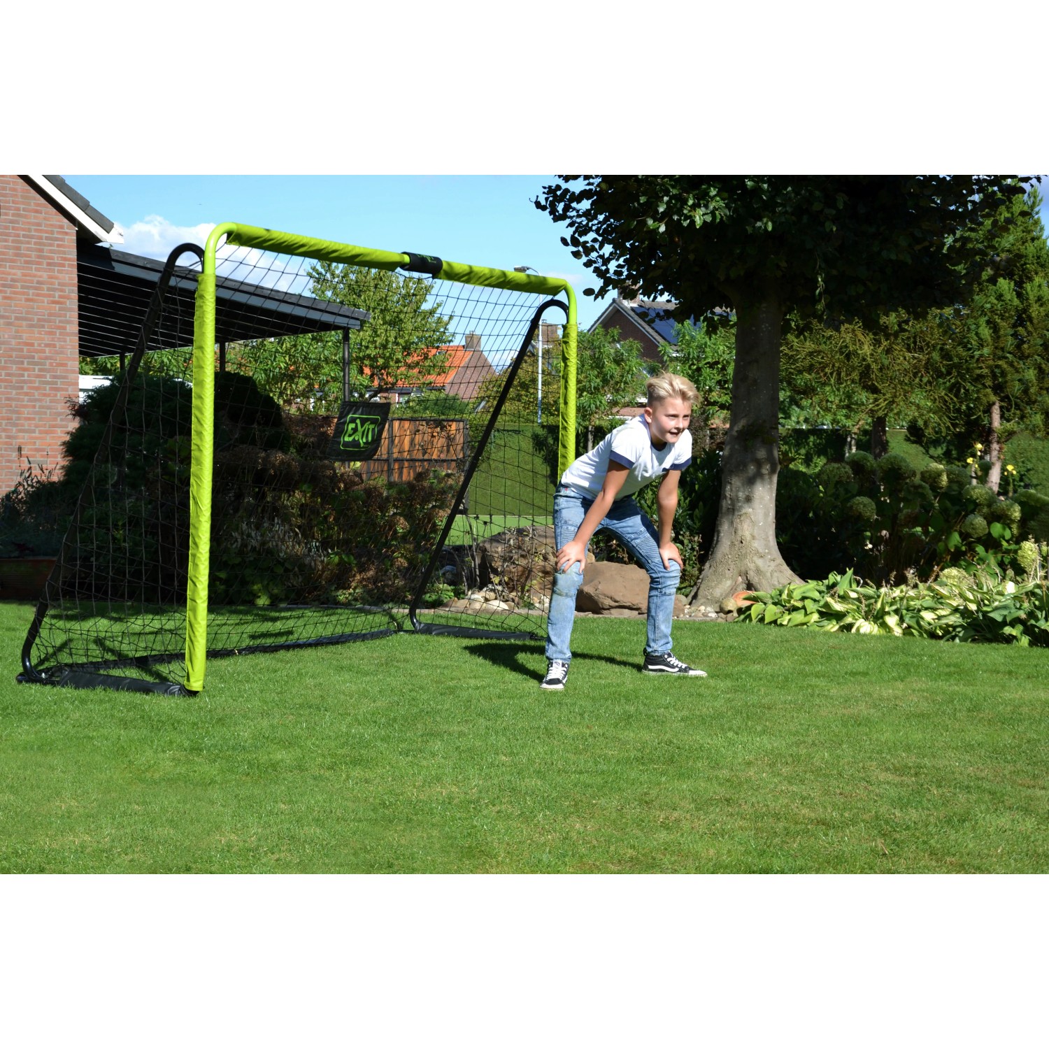 EXIT Tempo Fußballtor (240x160cm) in Grün/Schwarz mit Kind im Garten.
