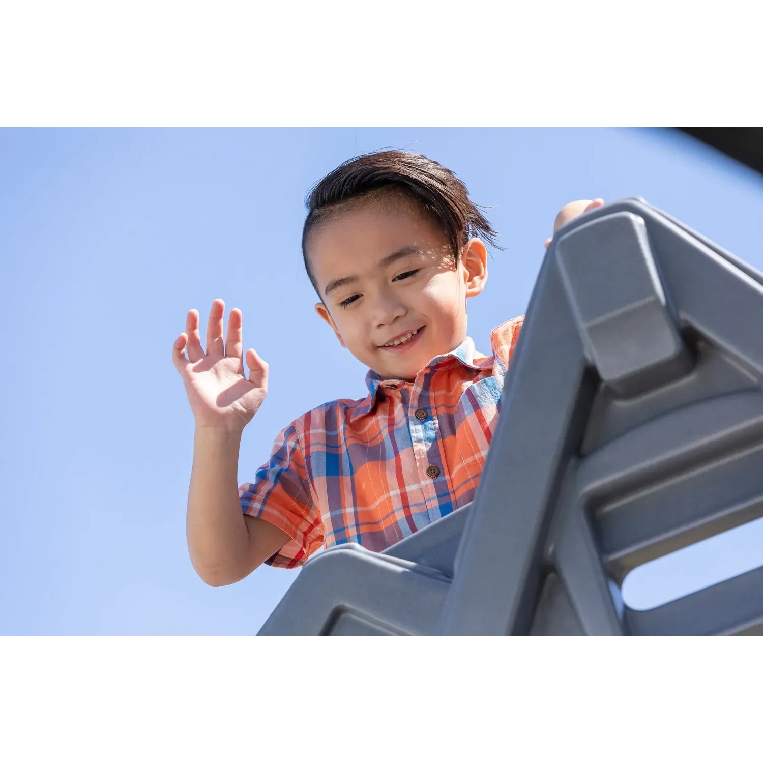 Kind winkt von der Rutsche des Step2 Spielhaus Adventures 2-Etagen.