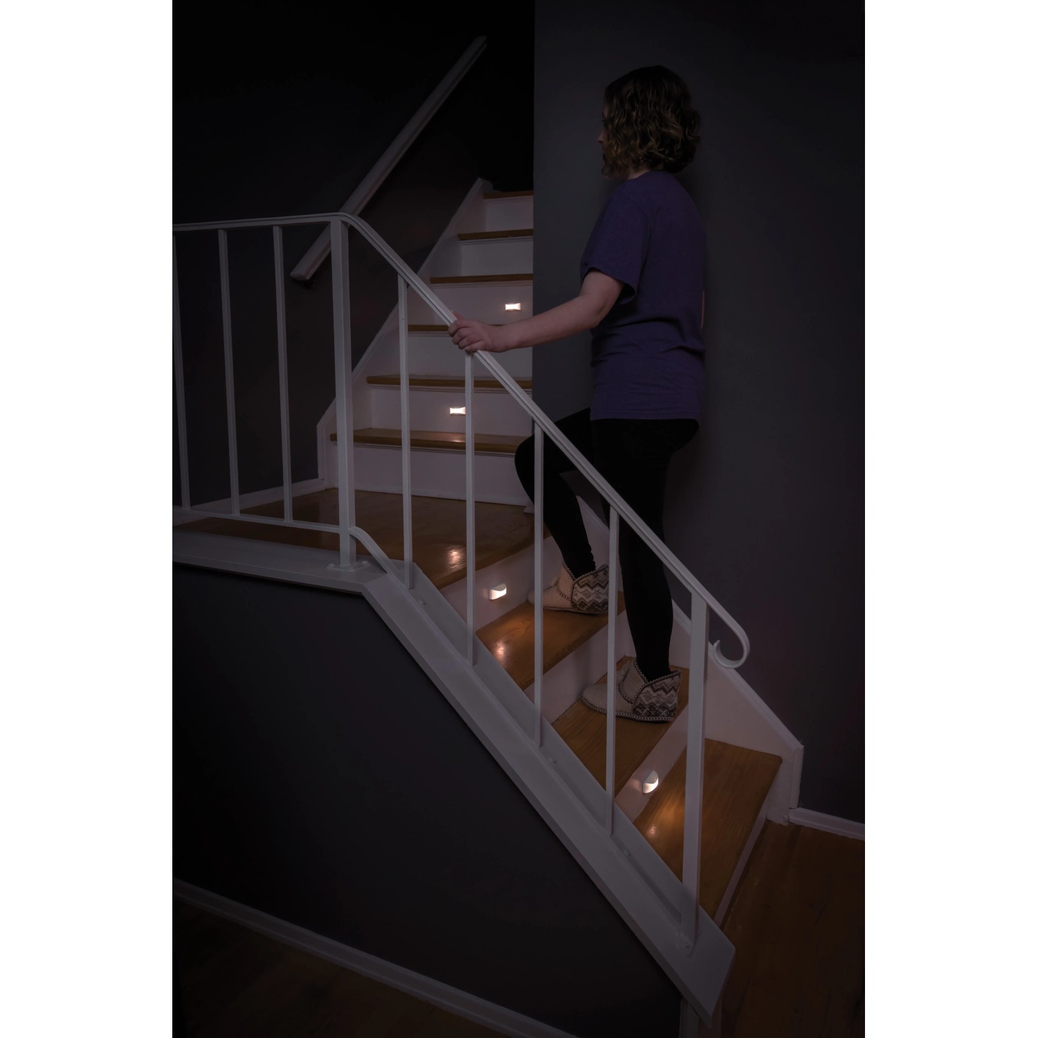 Frau steigt Treppe hoch, beleuchtet durch Mr.Beams Batterieleuchten MB500 Nachtlichter (2er-Pack).