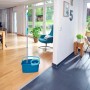 Leifheit Clean Twist Disc Mop Ergo Set mit blauem Eimer und Wischmop im Wohnraum.