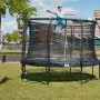 Schwarzes Salta Premium Gartentrampolin (ø 457 cm) mit Sicherheitsnetz und springendem Kind.