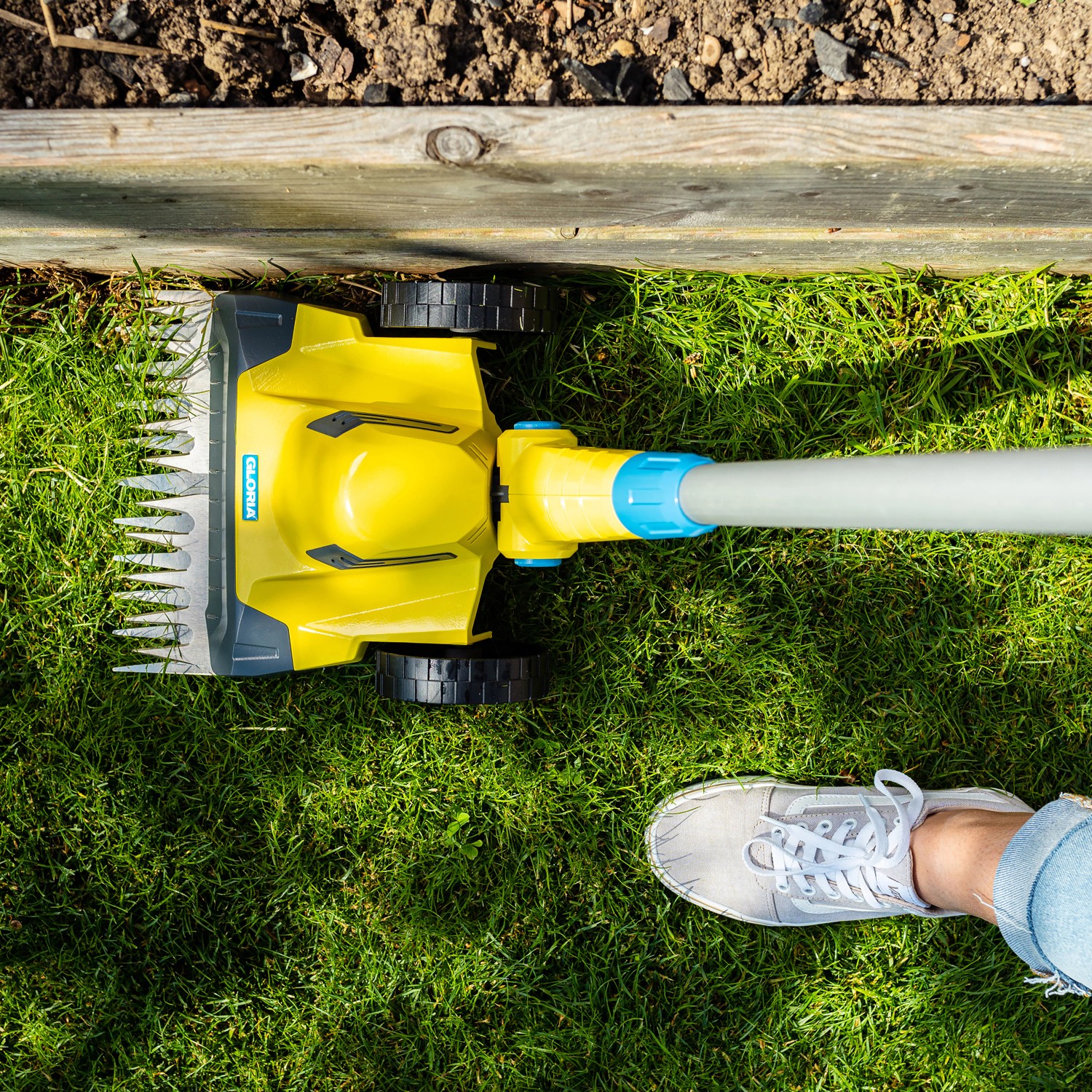 Gloria Finecut 18 V Akku-Rasentrimmer schneidet Rasenkante. Gelber Rasen- und Kantenschneider in Aktion.