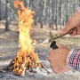 Wolfcraft Outdoormesser in Nutzung beim Anspitzen eines Holzstücks am Lagerfeuer.