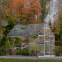 Palram Canopia Gewächshaus Silber 4,6 m² mit Fundamentrahmen im Garten.