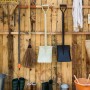 Relaxdays Fugenbürsten Set mit Teleskopstiel und 2 Aufsätzen an einer Holzwand.