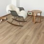 Verlegter Laminatboden Karisimbi Oak Breitdiele Eiche im Wohnraum mit Stuhl und Beistelltisch.