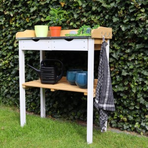 Axi Pflanztisch mit Schubladen, braun/weiß, mit Pflanzen, Gießkanne und Töpfen im Garten.