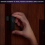 Philips Hue Kontaktsensor Secure 2er-Pack in Schwarz wird an einer Holztür befestigt.