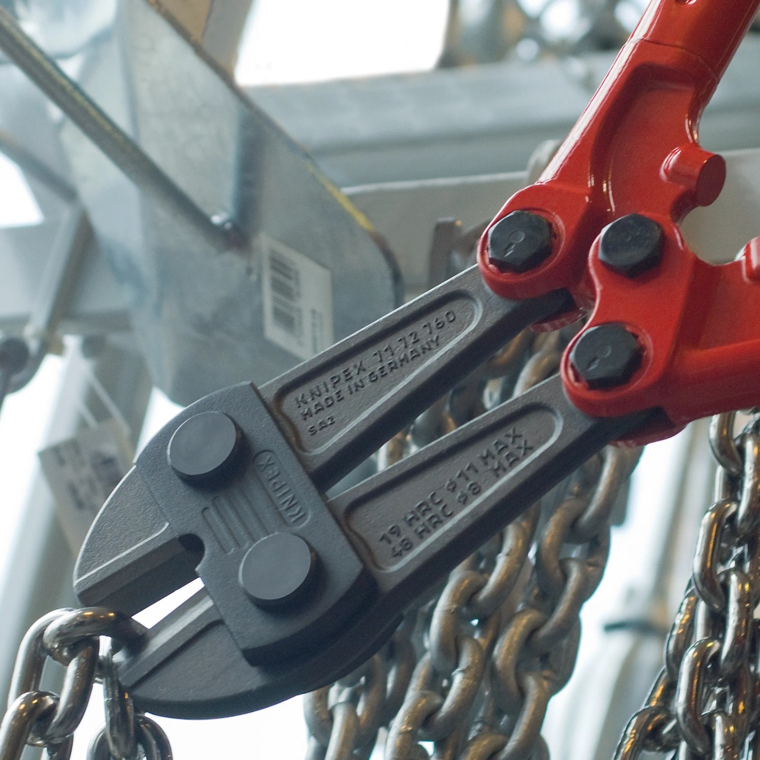 Knipex Bolzenschneider 610 mm schneidet Kette. Zange mit roten Griffen und grauem Kopf.