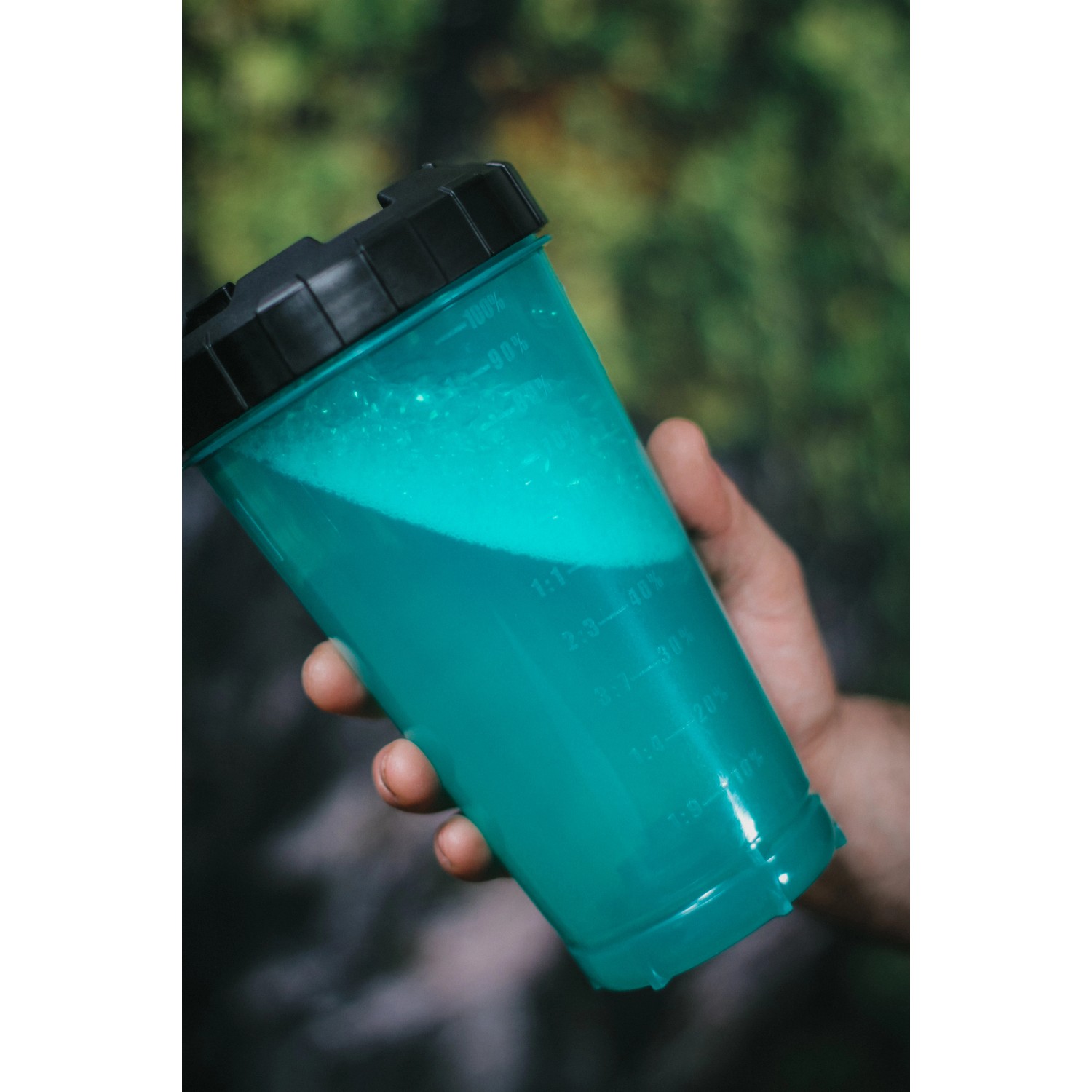 Ava Schaumkanone: Transparenter Behälter mit blauem Reinigungsmittel in Hand gehalten.