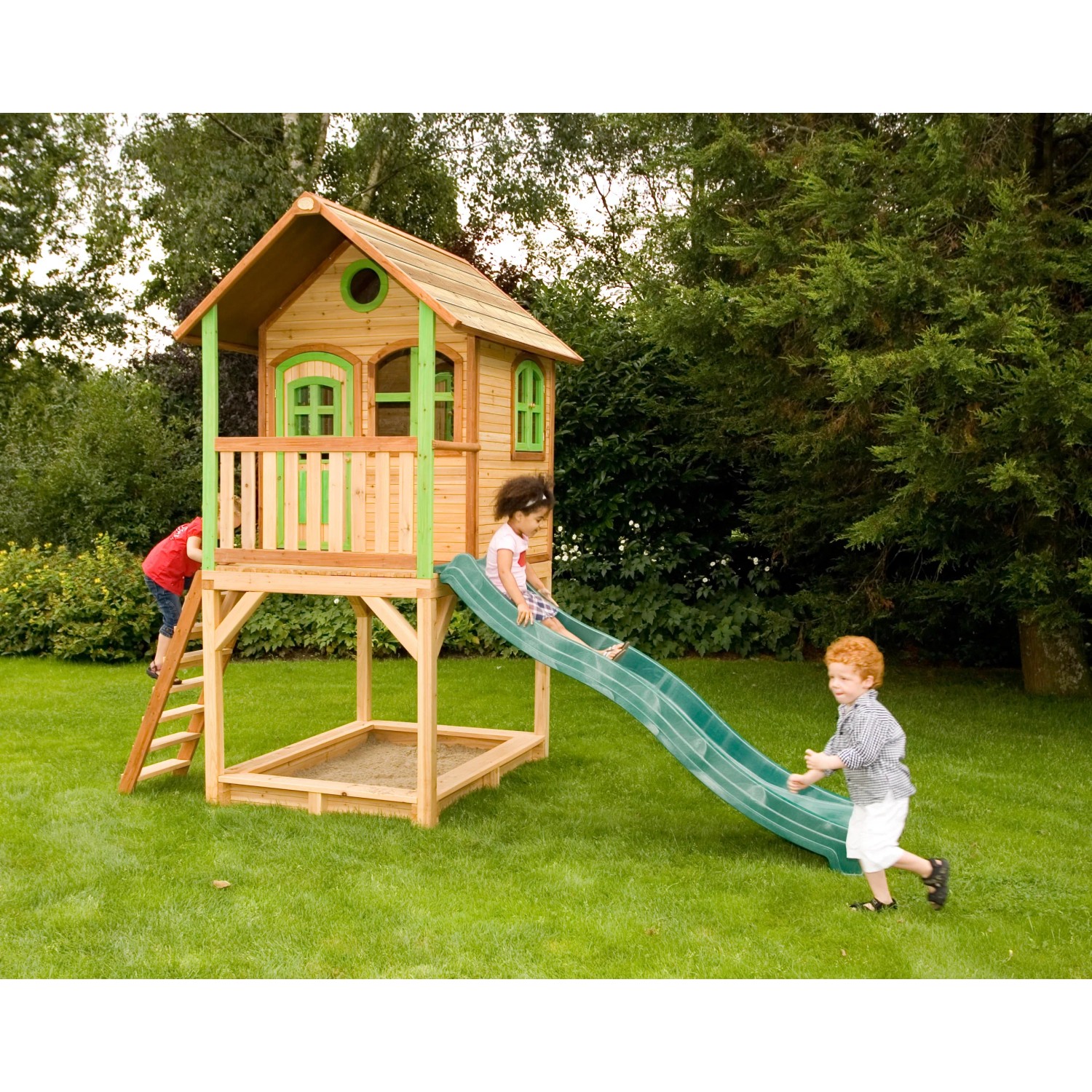 Axi Sarah Spielhaus aus Holz mit grüner Rutsche und Sandkasten für Kinder im Garten.