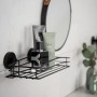 Schwarze Wenko Wandablage Vacuum-Loc mit Badartikeln an weißer Wand.