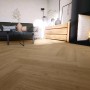 Anaturo Rigid-Vinylboden Mio 55 Eiche Barletta Fischgrät in Wohnraum-Szene.